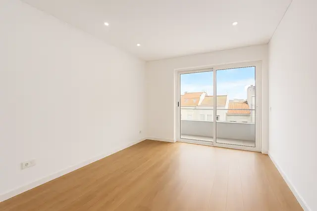 Sala com pavimento de madeira e porta de sacada